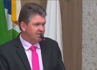 Vereador discursando ao microfone em plenário da Câmara de Sinop