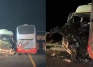 Caminhão com a frente destruída ao lado de dois ônibus parados na BR-163