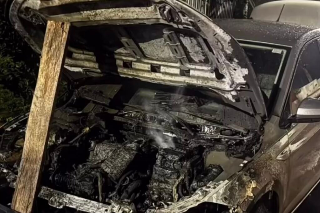 Capô aberto de carro com compartimento do motor completamente queimado