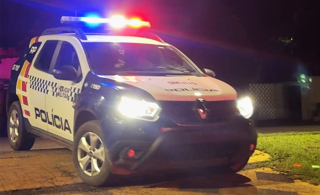 Viatura da Polícia Militar com luzes acesas durante a noite